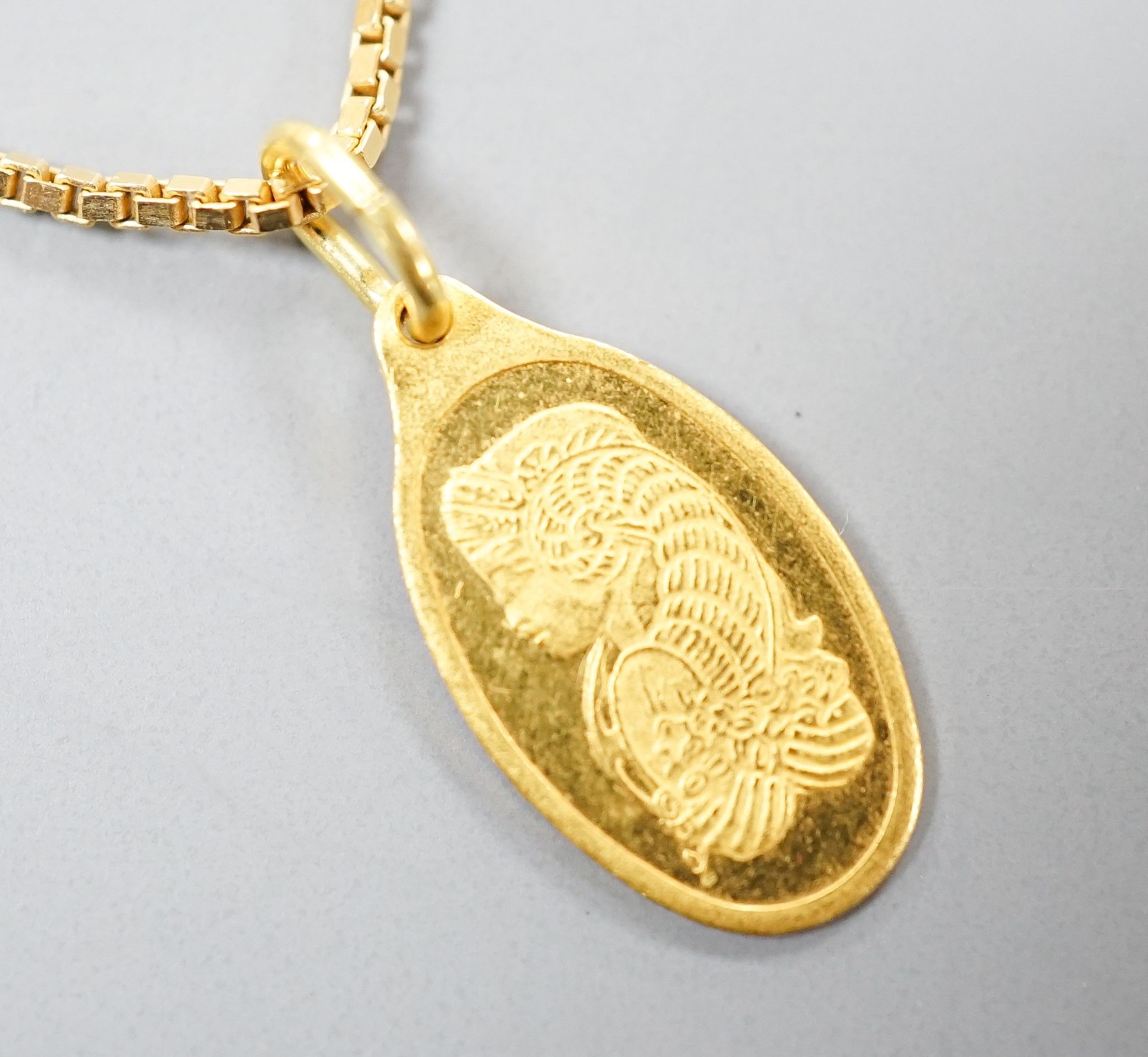 A Suisse '1g Fine Gold' yellow metal pendant, 15mm, on a 750 chain, gross 6.3 grams.